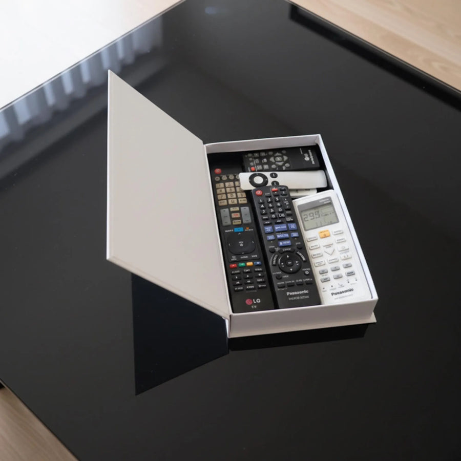 Faux book box opened, holding remote controls