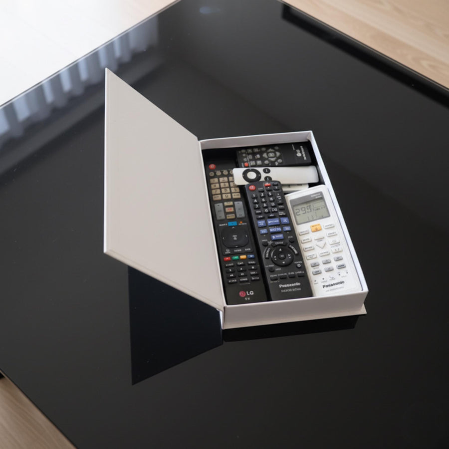 Faux book box opened, holding remote controls