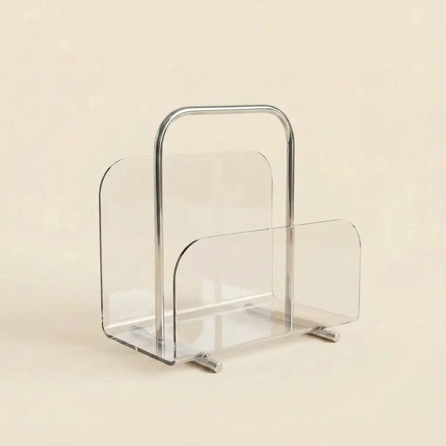 Clear Lucite Lumen Magazine Stand with a polished chrome carry handle, holding magazines