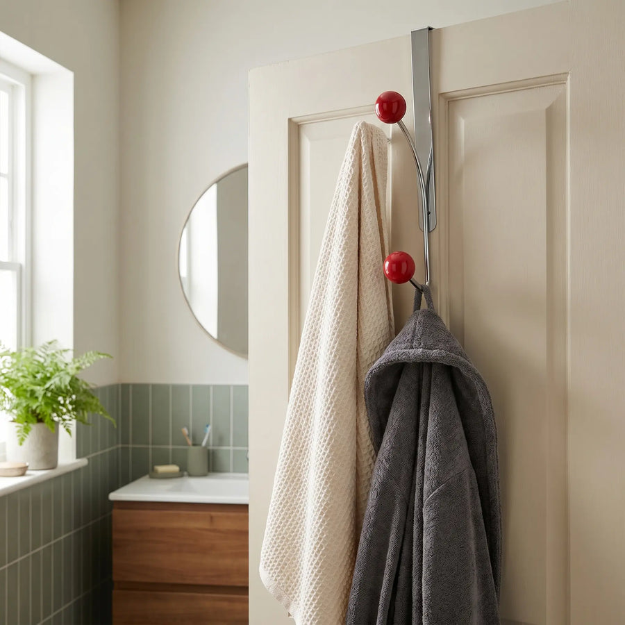 Nomad over-door rack on a bathroom door holding a towel and robe